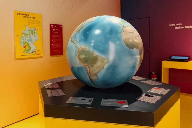 Eine Weltkugel steht auf einem schwarzen Sockel.