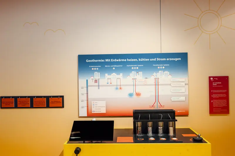 Das zeigt das Tropfexperiment mit verschiedenen Gesteinen und eine Informationstafel zur Geothermie.