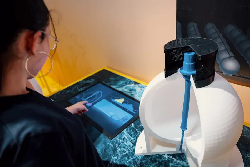 Das Bild zeigt das Modell eines Kugelspeichers und ein Mädchen, das den daneben platzierten Bildschirm bedient.