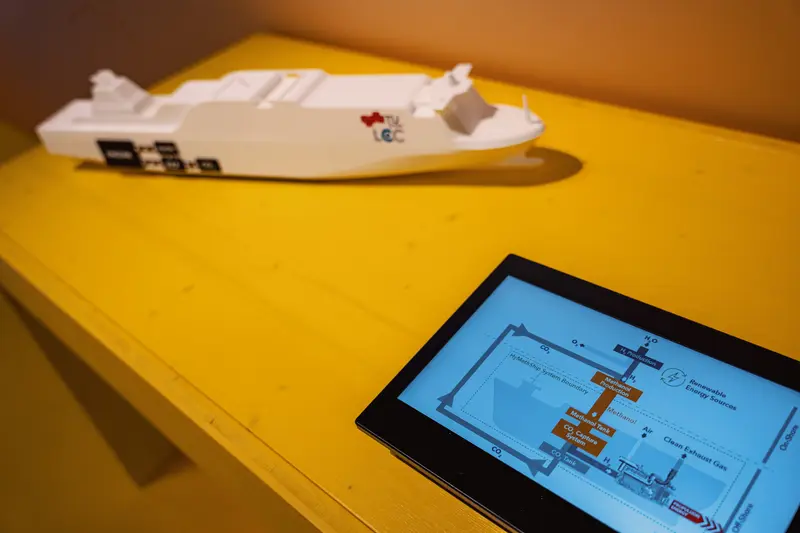 Das Bild zeigt einen Bildschirm und das Modell eines Schiffes.